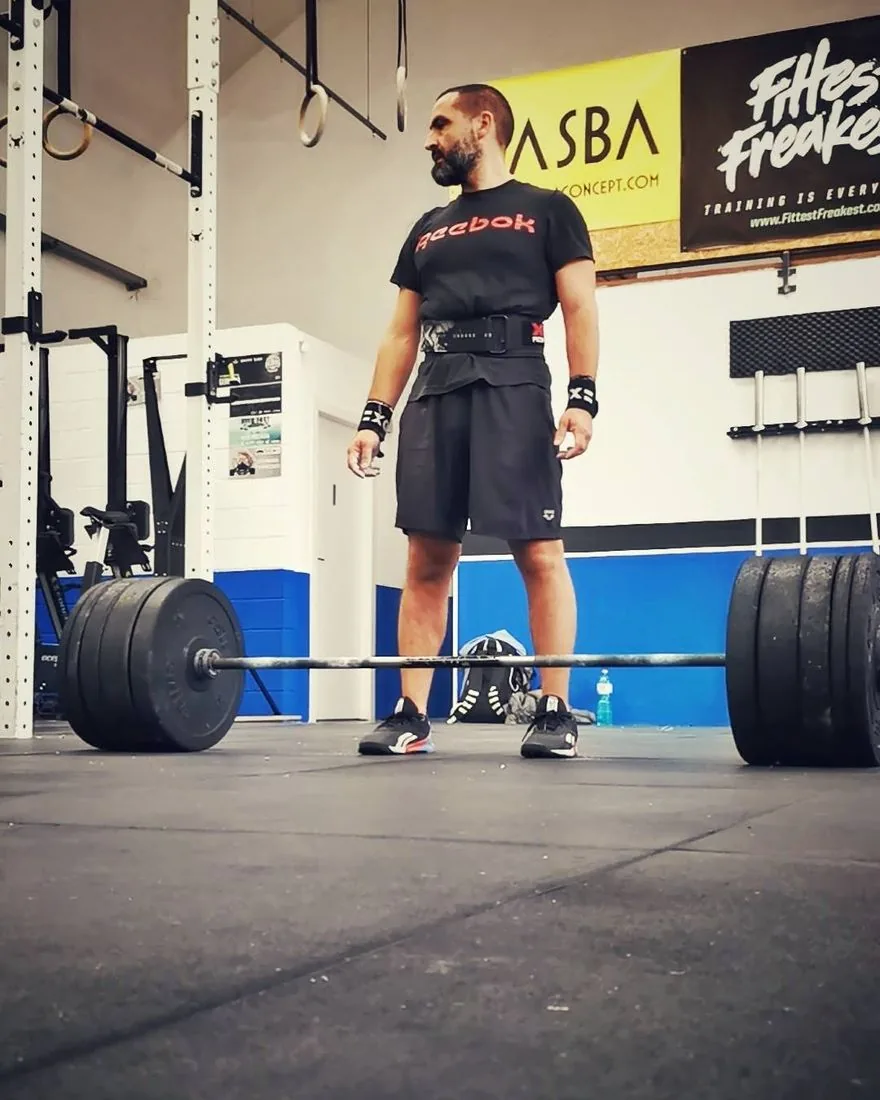 Benito in palestra davanti a un bilanciere carico, prima di un sollevamento